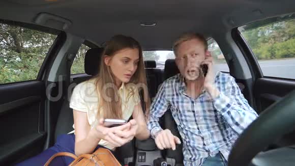 年轻人在电话里说话女孩在车里用智能手机视频的预览图