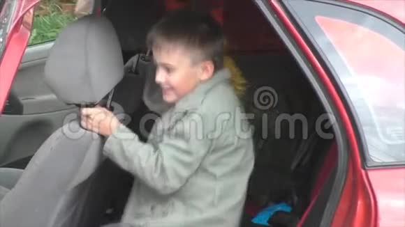有花束的男孩坐在车里视频的预览图