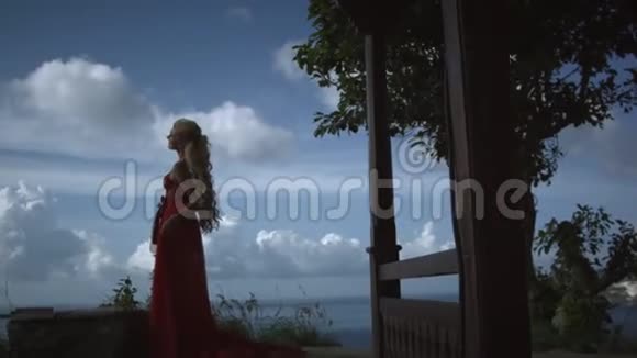 年轻浪漫的女人一头金发穿着优雅的红色裙子视频的预览图