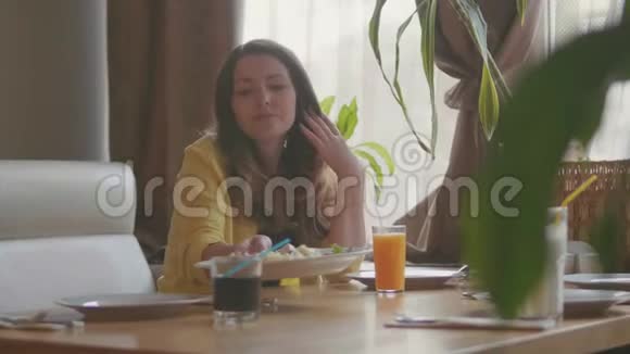 咖啡馆里的女孩快餐店慢动作视频在咖啡馆里的女人吃概念生活方式视频的预览图