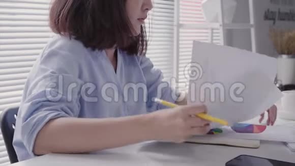 美丽的年轻拉斯特亚裔妇女在家里坐在客厅里用笔记本电脑工作亚洲商界女性工作视频的预览图