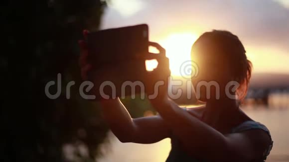 年轻女子用手机在苏梅岛热带海滩自拍日落1920x1080视频的预览图