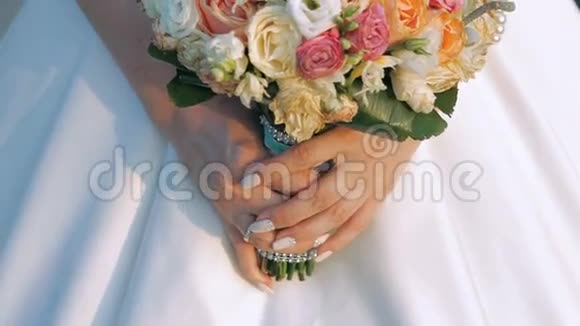 美丽的新娘手中的新娘花束穿着礼服慢慢地视频的预览图