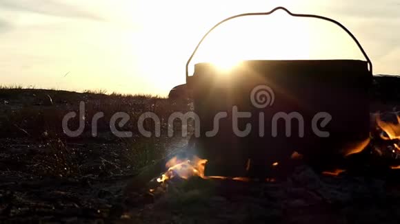 黑锅站在篝火里日落时分它会慢慢地烧热水视频的预览图