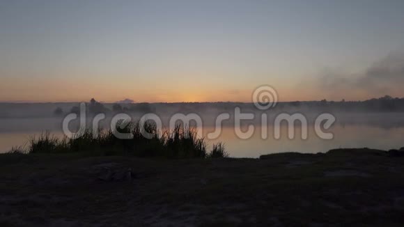 在夏日灿烂的夕阳下的一个湖它被雾覆盖了视频的预览图