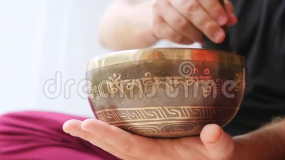 传统藏传唱碗人类在青铜冥想碗上演奏平静的声音有利于良好的能量和健康4K视频的预览图