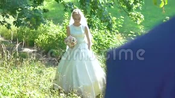 新娘在公园的新郎面前旋转慢慢地视频的预览图