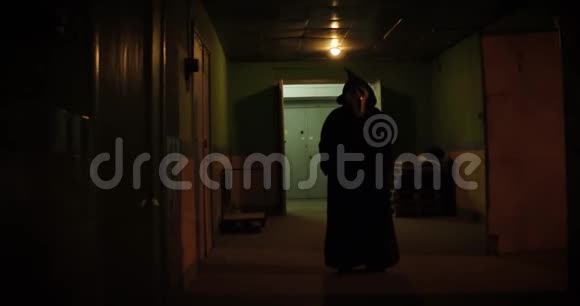 一个戴着面具的可怕男人在长长的走廊里视频的预览图