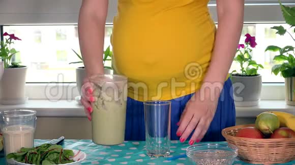 孕妇双手将健康水果鸡尾酒倒入玻璃杯视频的预览图