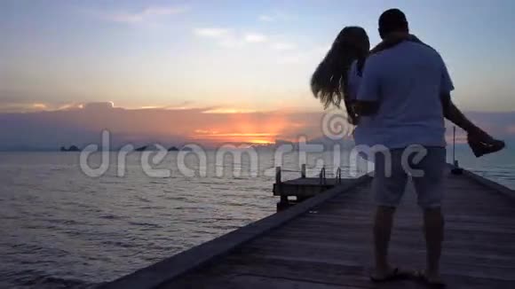 一对在日落码头玩得开心的浪漫夫妇视频的预览图