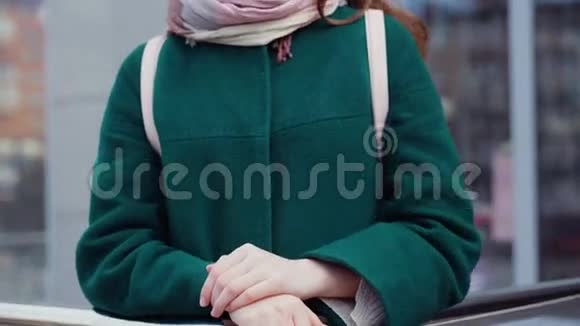一位年轻的黑发女子穿着外套在一条城市街道上视频的预览图