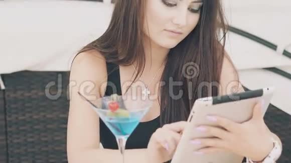 年轻女孩使用数字平板电脑休息在海滩休息室慢慢地视频的预览图