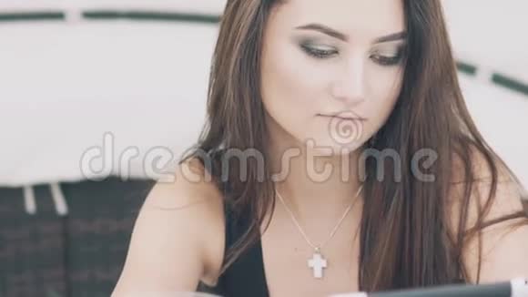 漂亮的女孩使用数字平板电脑休息在海滩休息室慢慢地视频的预览图