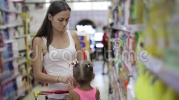 小女儿的年轻女性选择超市里的清洁剂视频的预览图