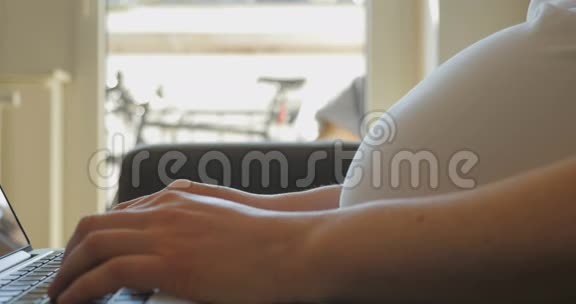 怀孕妇女在打字2时腹部概况视频的预览图