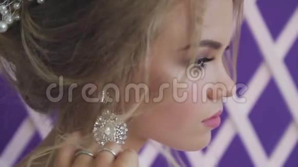 非常漂亮的金发碧眼穿着紫色背景的白色新娘礼服视频的预览图