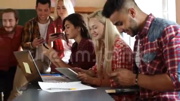学生使用手机坐课桌大学教室人群微笑视频的预览图