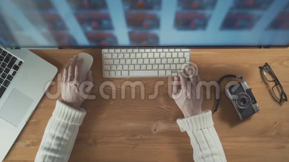创意摄影师使用鼠标和键盘从显示器上挑选照片视频的预览图