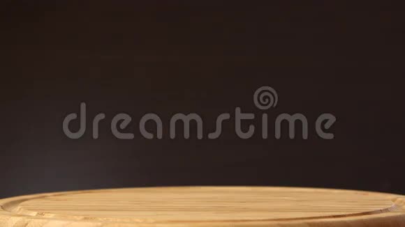 女性的手把成熟的热带椰子放在木制桌子上背景是黑色的热带水果视频的预览图