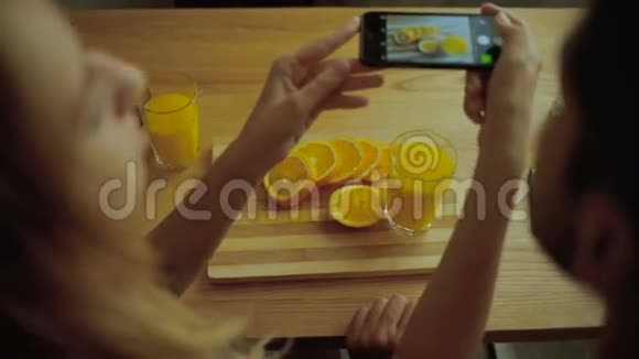 女士在厨房里给美味的橘子拍照视频的预览图