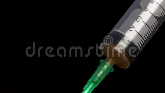 把疫苗从黑色背景上的安瓿中放入玻璃注射器中特写镜头注射器输入流体注入视频的预览图