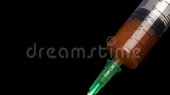 把疫苗从黑色背景上的安瓿中放入玻璃注射器中特写镜头注射器输入流体注入视频的预览图