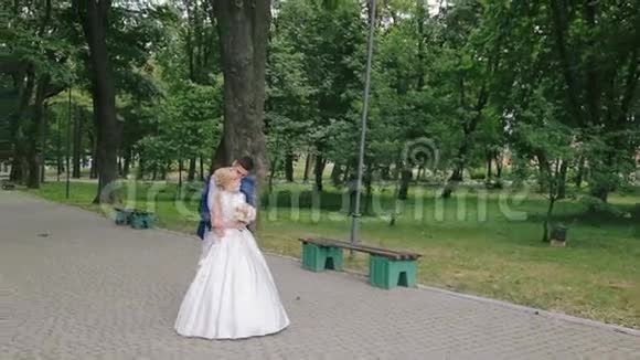 新婚夫妇在公园里休息拥抱和散步视频的预览图