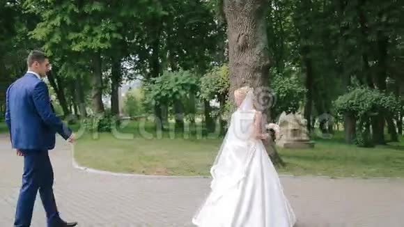 新郎在公园里跟着她的新娘视频的预览图