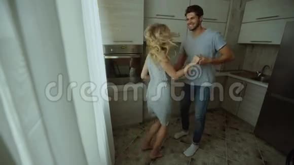 男人和女人在家里的厨房里跳舞视频的预览图
