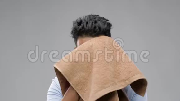 戴着灰色背景毛巾的印度男人视频的预览图