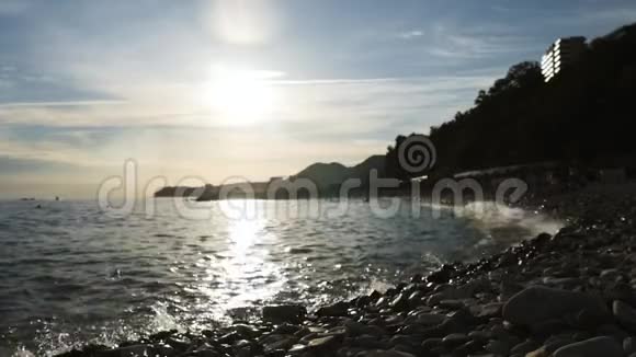 夕阳西下的海山沙滩上的太阳落山人们在沙滩上视频的预览图