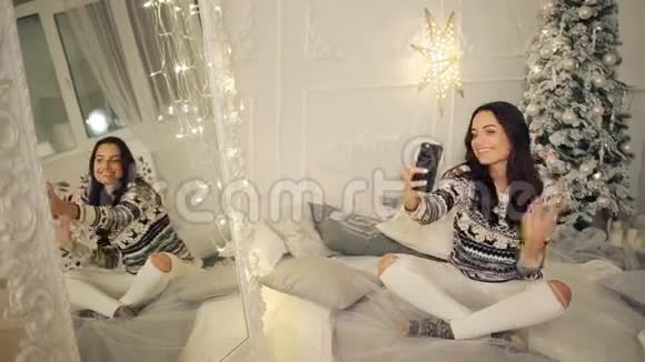 假日冬天和人们的概念快乐的年轻女子在家中的圣诞树上自拍视频的预览图