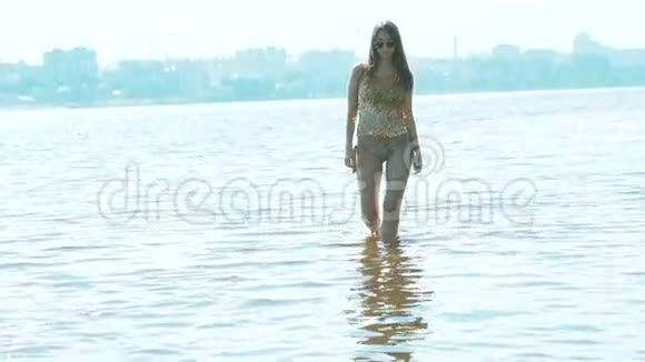 穿着迷人的泳装在河里奔跑摆姿势的女人慢动作视频的预览图