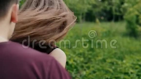 女人的手触摸树叶美丽的年轻女子走在她的男人面前转过头慢慢地稳定地射击视频的预览图