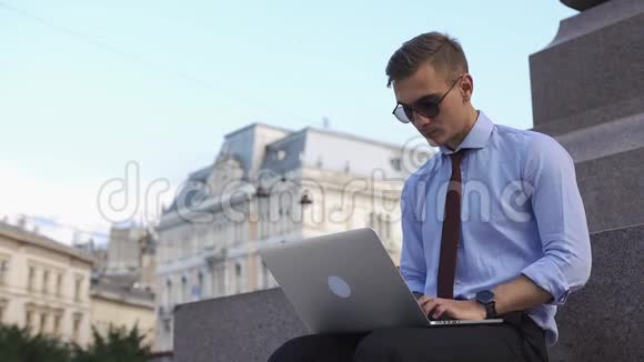 一个人拿着笔记本电脑在街上工作视频的预览图