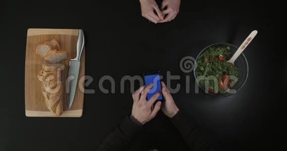 手放在厨房的桌子上双手滚动手机屏幕上景视频的预览图