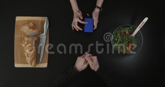 厨房桌子上的俯视图手拿着蓝屏的手机视频的预览图