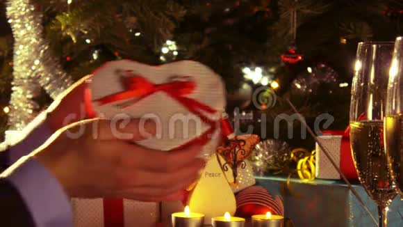 一对夫妇庆祝圣诞节男人的双手送礼物看上去像一颗心视频的预览图