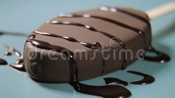 巧克力釉中的冰淇淋躺在盘子上绕轴旋转特写视频的预览图