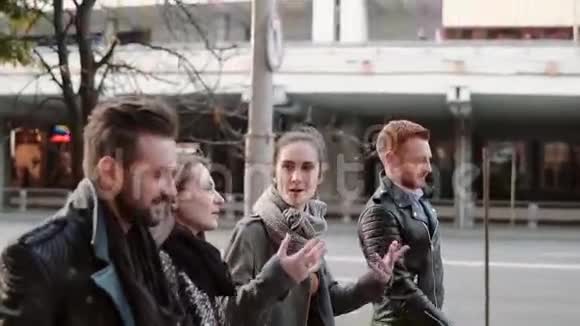在市中心微笑的人们兴高采烈地走在路边朋友散步聊天斯泰迪加姆慢点视频的预览图