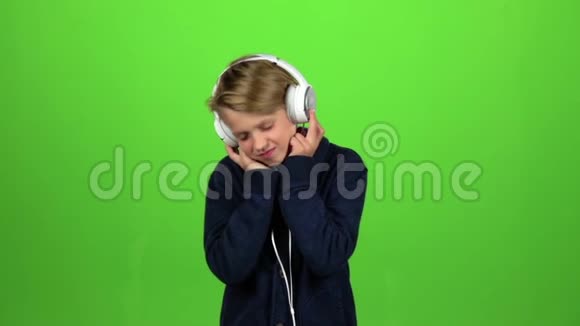 耳机里的孩子在听音乐绿色屏幕慢动作视频的预览图