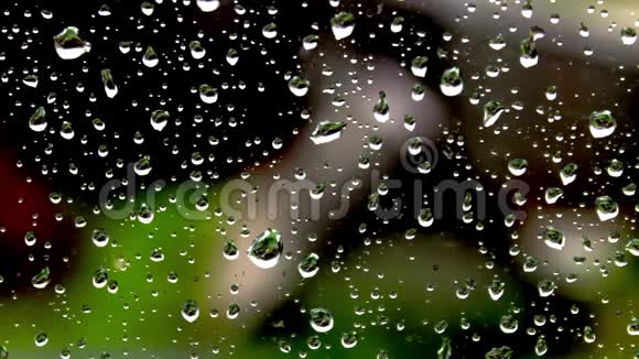 在房子背景下的窗玻璃上落下的雨水视频的预览图