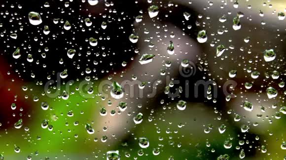 大自然背景下窗玻璃上的雨点视频的预览图