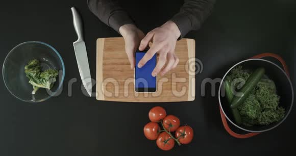 哈兹滚动手机屏幕厨房桌子上有食物刀和切割板上景视频的预览图