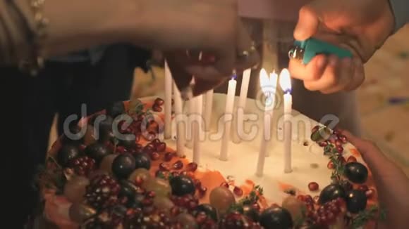 人们的手在结婚蛋糕上点燃蜡烛视频的预览图