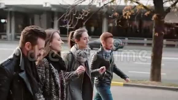 在市中心微笑的人们兴高采烈地走在路边朋友散步聊天斯泰迪加姆慢点视频的预览图