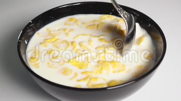 用勺子把玉米片混合在牛奶里视频的预览图