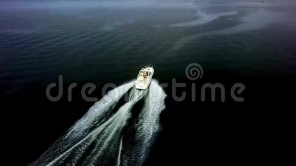 令人惊叹的4k空中无人机观景豪华白色游艇摩托艇在平静的深蓝河水中缓慢航行视频的预览图