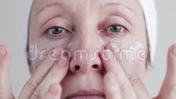 白人中年妇女在脸上涂奶油视频的预览图