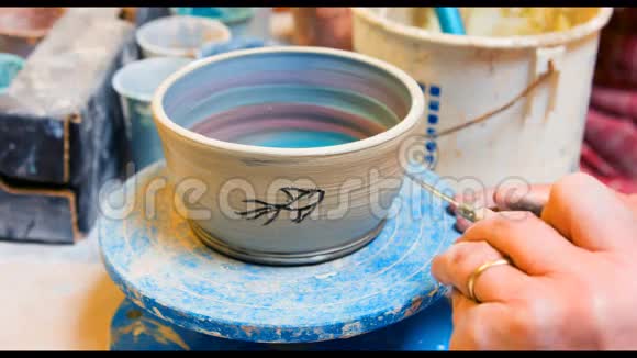 艺术家在陶器碗上作画的手视频的预览图